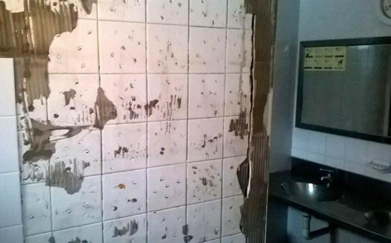 Paredes con azulejos caídos en el interior de los baños de las Cabañas del Pipo 
